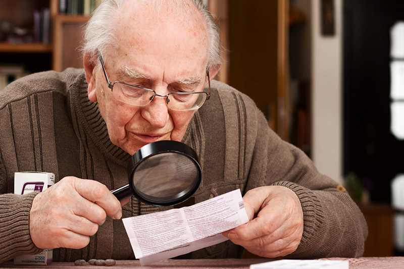 Senior with magnifier reading package insert